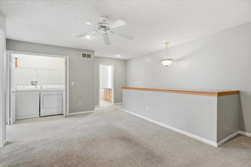 Upper-level laundry room with side-by-side washer and dryer for added convenience and easy everyday living.