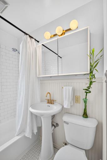 The cute main-level full bath features classic details and updated hardware.