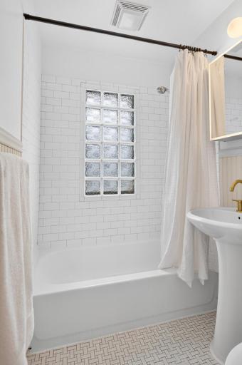 A glass-block window fills the main-level bath with softly filtered natural light.