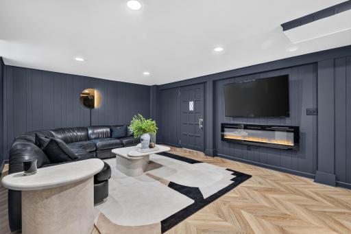 The remodeled lower-level family room features new drywall, LVP flooring and a modern electric fireplace.