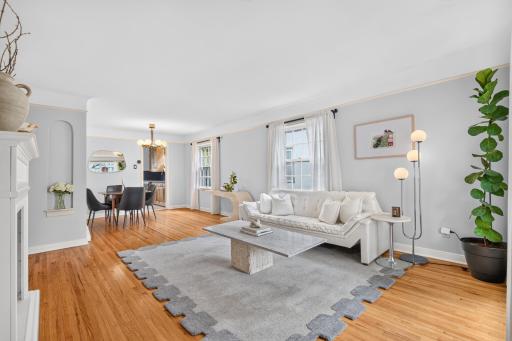 The bright living room showcases gleaming hardwood floors, coved ceilings and abundant natural light.