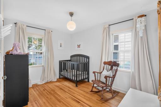 One of two main-level bedrooms, offering hardwood floors and dual windows.