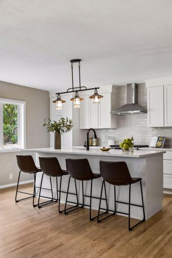 The tile backsplash goes behind the vent and up to the ceiling.