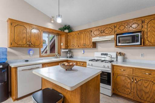 View of vaulted kitchen and window with center island and newer appliances