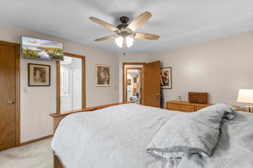 Primary bedroom with view to walk in closet, 3/4 bath and view to hallway and full bath