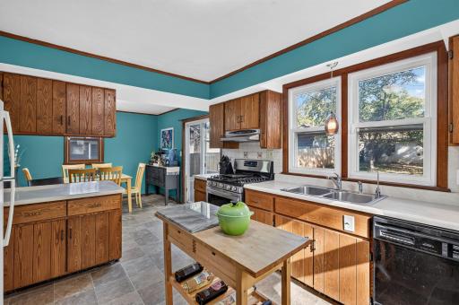 Kitchen boasts lots of cabinets, backsplash, gas stove, huge window for natural lighting, breakfast bar.