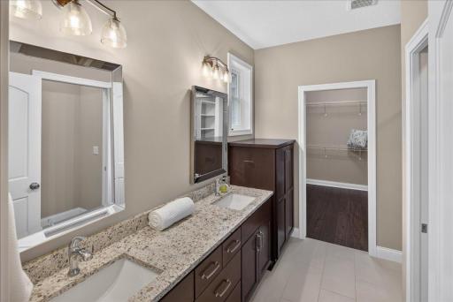 Primary en suite with granite countertops, double sinks and built-in storage