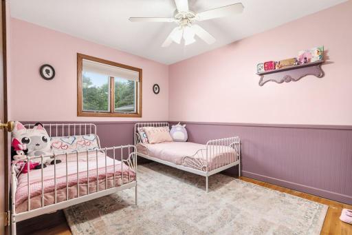 Main floor bedroom features wood flooring and new paint