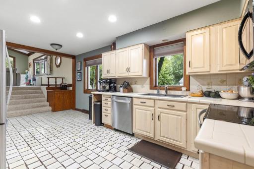 Walk-through kitchen with tiled flooring and stunning cream colored cabinets