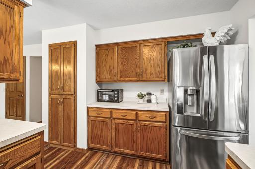 Another view of the kitchen showing the built-in pantry, additional cabinetry, and counter space.