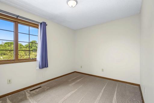 Bedroom #3 has a window that overlooks the front yard and new neutral carpet.