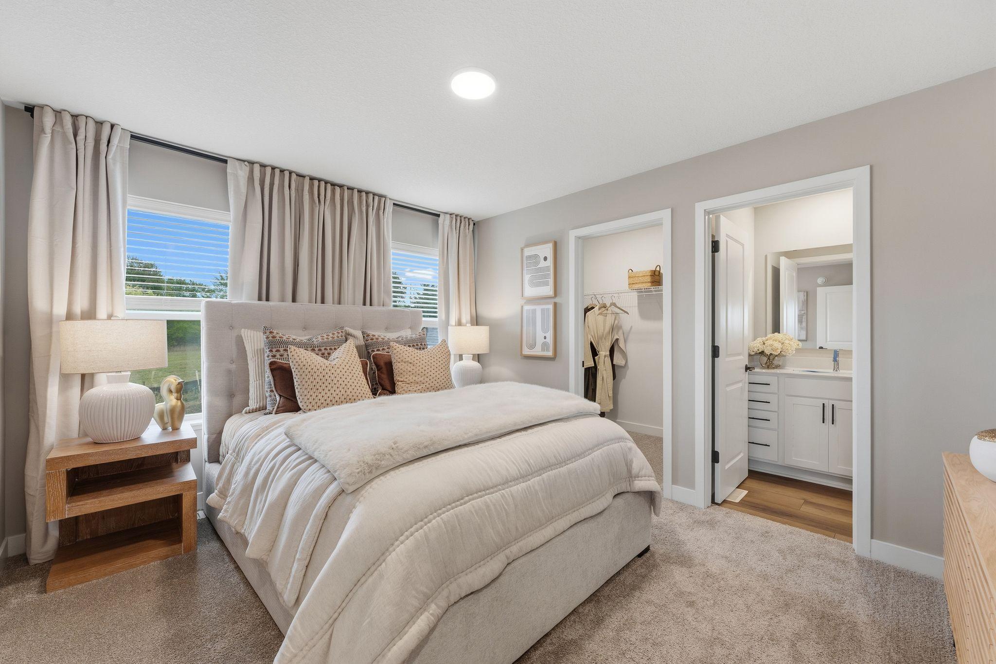 The owner’s suite is a serene retreat featuring a large bedroom with an attached bathroom and walk-in closet.