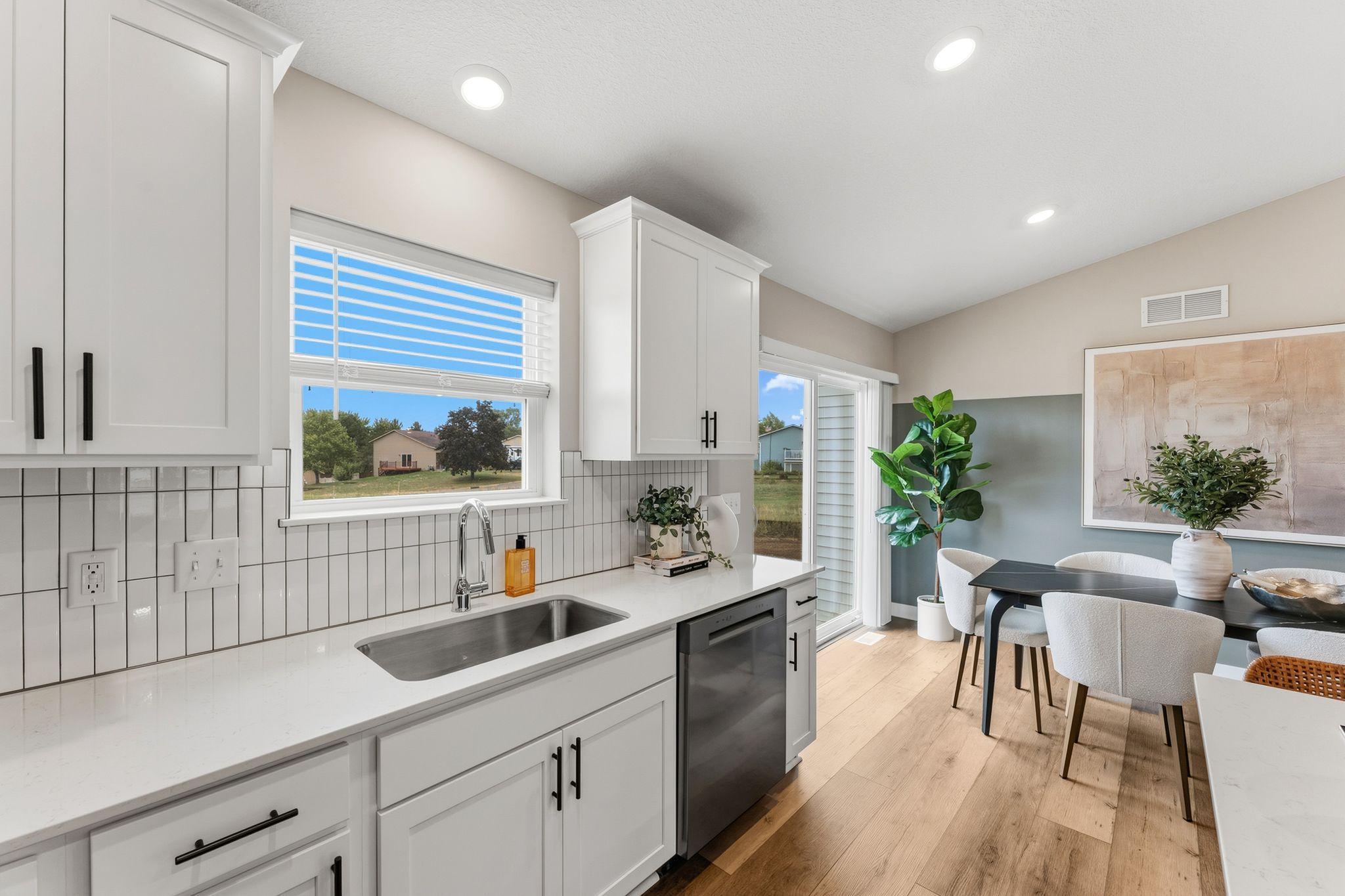 Durable quartz countertops and ceramic tile backsplash provide stylish functionality to the kitchen