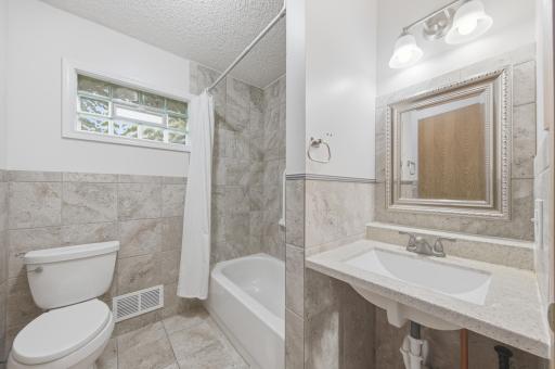 Full handicap accessible bathroom. Extra wide doorway and sink without the base. Tile flooring and walls, hard surface sink.
