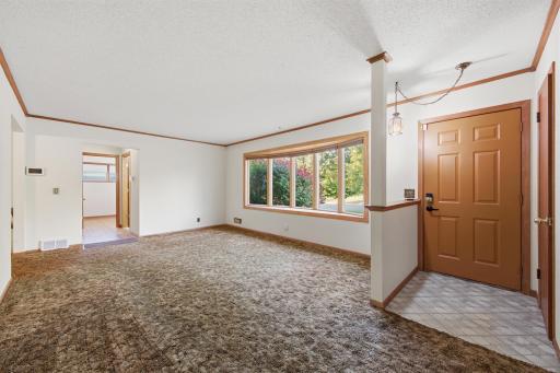 Beautiful bow window overlooks the front yard. Hardwood floors are under the living room carpet. Details like the wood molding are extras!