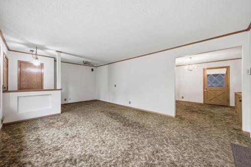 Living room opens to a large dining space. Door leads to the maintenance free deck.