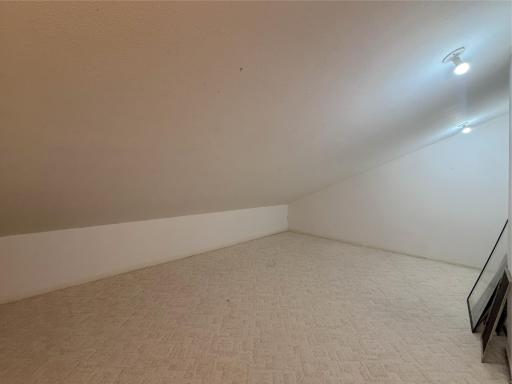 Spacious storage area located just off the primary bedroom, offering plenty of room for seasonal items or create a large walk-in closet.