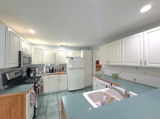 Bright and functional kitchen featuring abundant cabinetry, generous workspace and a peninsula with additional prep space and seating potential.