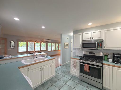 Spacious kitchen offering plenty of cabinet and counter space, with a convenient peninsula that opens to the lakeside dining area and beautiful water views.