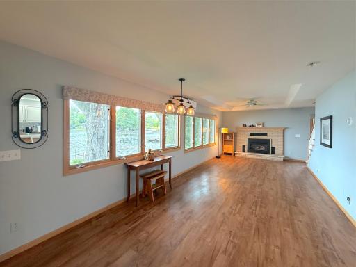 Lakeside dining and living space filled with natural light from a wall of windows showcasing beautiful lake views. Plenty of room for dining, relaxing and entertaining.