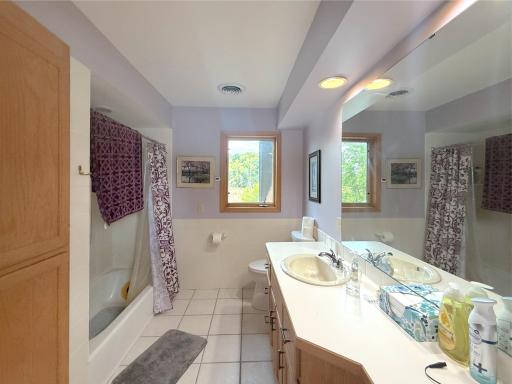 Spacious primary full bathroom featuring a large vanity with plenty of counter space, built-in storage and a tub/shower combination.