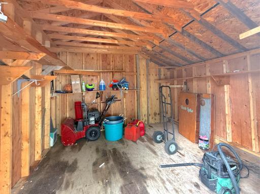 Inside, the spacious shed provides plenty of room for larger equipment along with built-in shelving for organized storage.