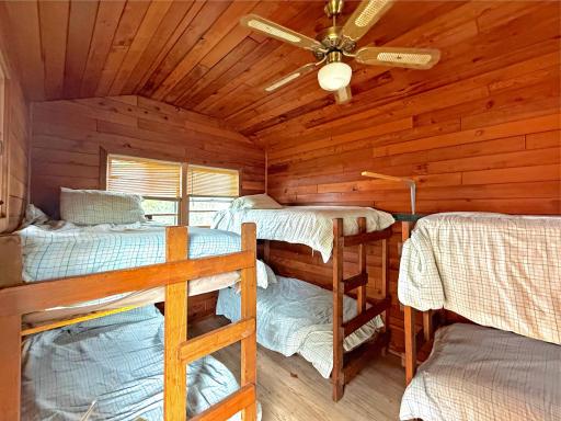 Inside, the lakeside shed offers a cozy bunkhouse setup with plenty of sleeping space for extra guests after a full day on the lake.