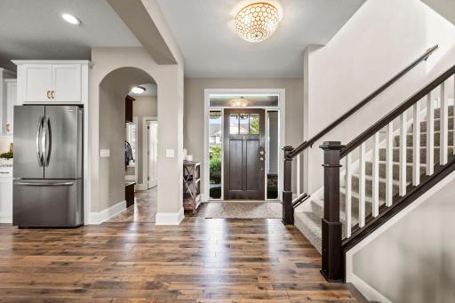 Welcoming foyer with rich hardwood flooring that continues into the kitchen and informal dining area.