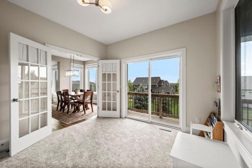 Private main-floor office tucked behind glass-paneled French doors. Convenient access to the expansive covered deck extends the living space outdoors.