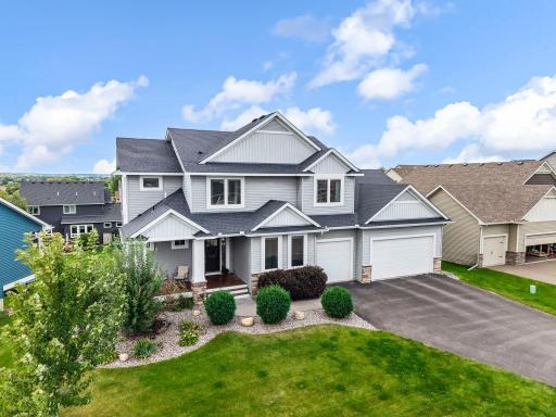 Two-tone vinyl siding, stone accents, and mature landscaping.