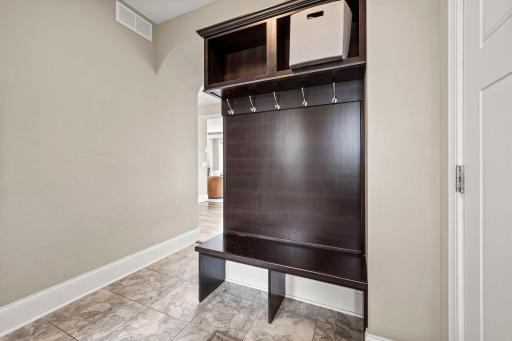 Tiled mudroom provides convenient everyday access directly from the three-car garage. Built in Coat hooks and cubbies for convenient storage when you arrive home