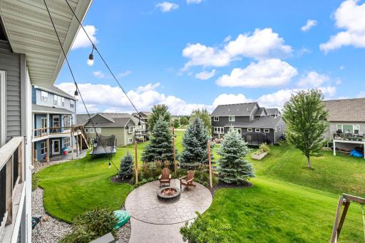 View from the deck of oversized stamped-concrete firepit area that creates a dedicated gathering space.