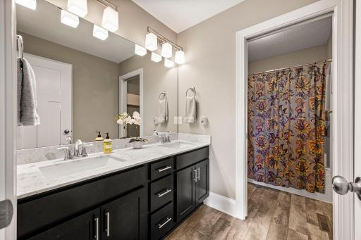 Full hallway bath features a dual-sink vanity for added everyday convenience.