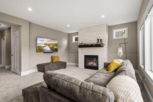 Floor-to-ceiling bright white stone creates a dramatic backdrop for the gas fireplace.