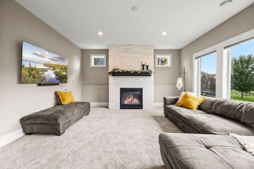 Brand-new carpet gives the lower-level family room a fresh, finished feel. Wood mantel adds warmth and contrast to the lower-level fireplace.