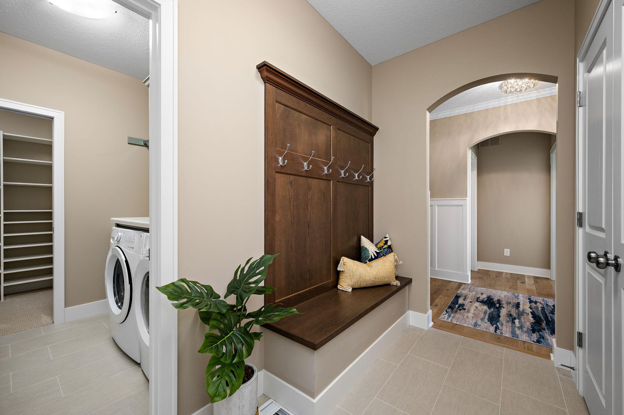 Back entry off the garage with built-in bench, closet and arched opening.