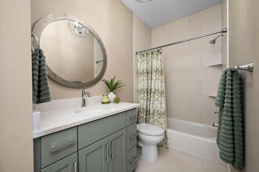 Main level full bath with tile to the ceiling and quarts countertop- also includes a linen-Not shown in photo.