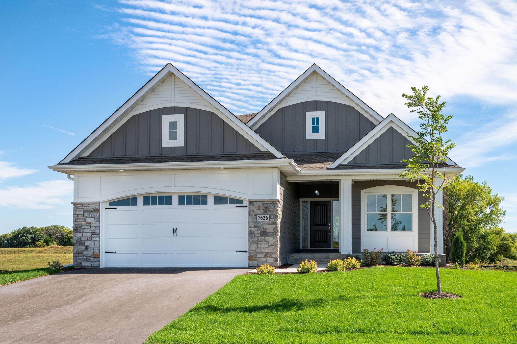 Welcome to 7626 Fir Ln in Corcoran. Our brand new Villa community, Fairway Shores Villas at Cook Lake. Exterior features James Hardie Siding, Andersen Windows, real stone accents and a stamped concrete front porch.