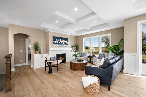 Great room with built ins, stone fireplace, vaulted a beamed ceiling, real solid white oak hardwood floors and large windows.