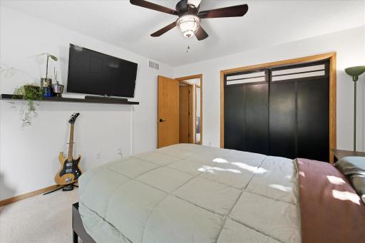 Another view of the primary bedroom showcasing its comfortable proportions, own closet space, and ample wall space for furnishings and dÃ©cor.