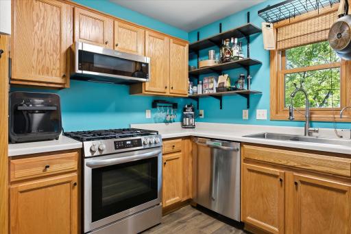 Additional kitchen view highlighting the ample cabinetry, stainless steel appliances, large sink, and natural light from the window.