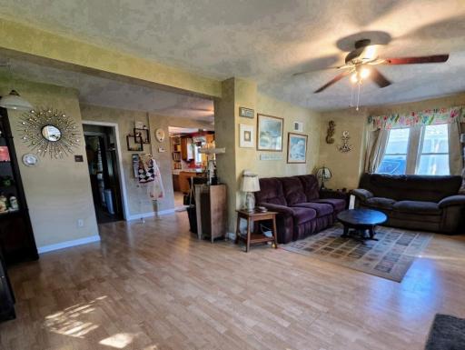 View of living room, hallway to bath/bedroom, kitchen & dining.