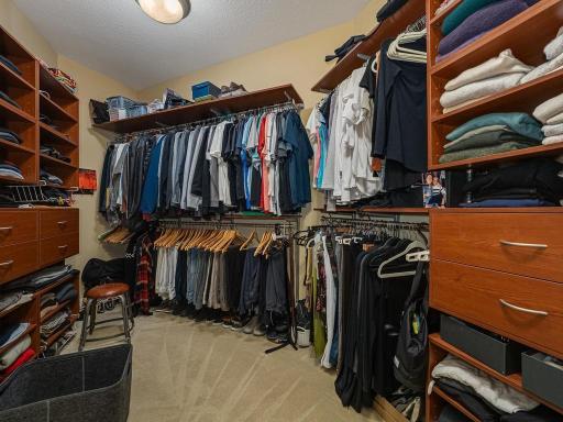Primary walk in closet with built in shelving