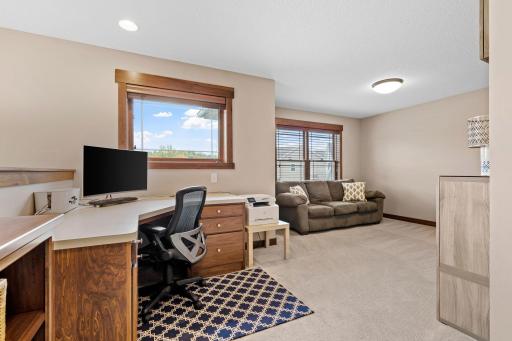 Large windows fill the spacious upper-level loft with natural light, while a built-in desk creates the perfect spot for homework, work-from-home needs, or everyday organization.