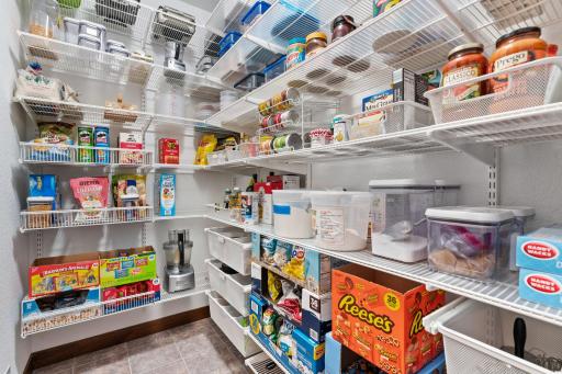 The incredible walk-in pantry is outfitted with a custom Elfa organization system, offering an impressive amount of organized storage.