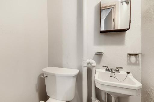 Convenient lower-level half bathroom located near the laundry and utility area.
