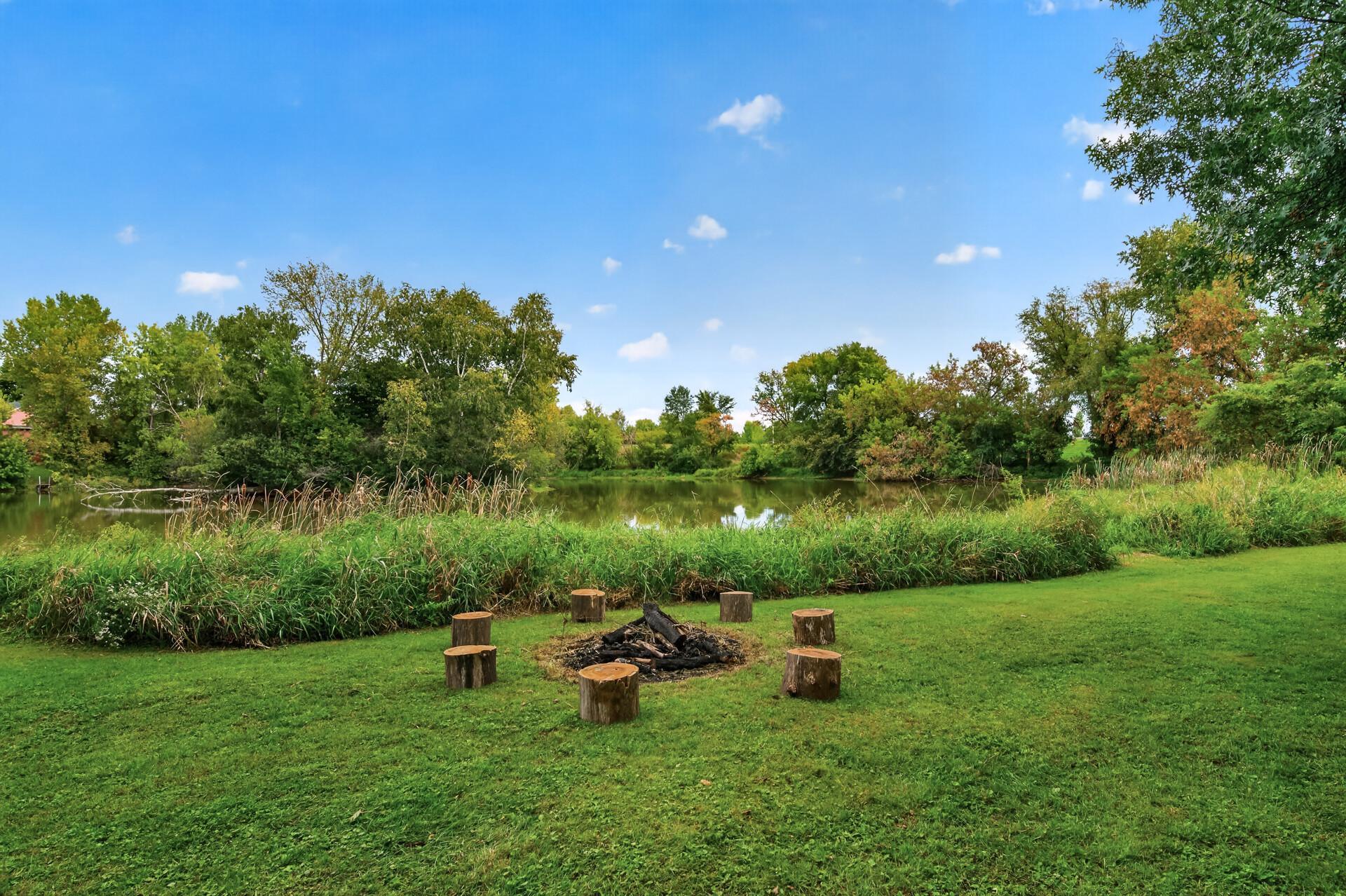 Firepit with views of the large pond at the back of the property.
