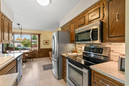 Designed for cooking and gathering, the fully renovated kitchen (2022) comes equipped with gorgeous marble countertops, a tile backsplash, stainless steel appliances, and a sunny breakfast nook.
