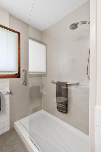 Features new flooring, vanity, and shower surround.