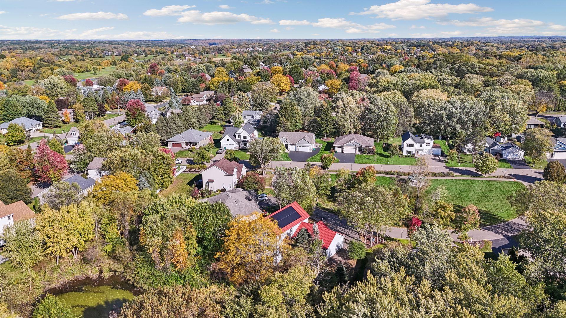 Another beautiful aerial perspective highlighting the home's striking metal roof and solar panels, combining distinctive style with energy-conscious features.
